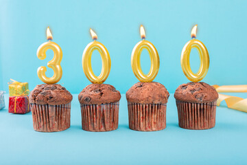 3000 Number gold candle on a cupcake against a pastel blue background three thousand year...