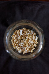 Orzechy cashew w dużym szklanym słoju na ciemnym tle