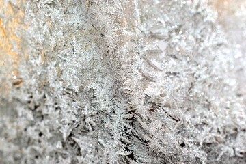 Glass covered with patterns and crystals of frost in winter