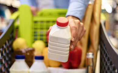Closeup of man shopping groceries, buying milk