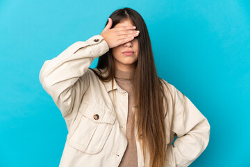 Young caucasian woman isolated on blue background covering eyes by hands. Do not want to see something