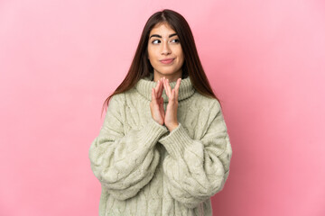 Young caucasian woman isolated on pink background scheming something
