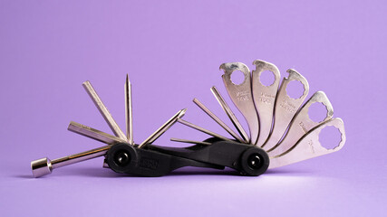 Bicycle bike portable mini multitool repair tools on a purple background. Bike multi tool. Bike repair tool kit.