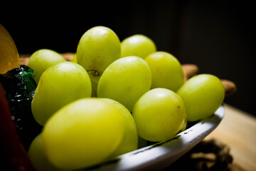 Uvas en plato con fondo negro