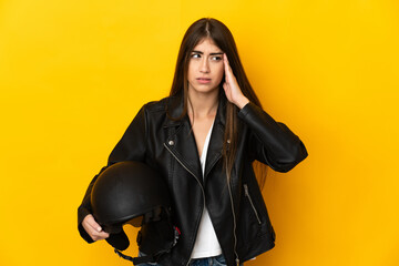 Young caucasian woman holding a motorcycle helmet isolated on yellow background with headache