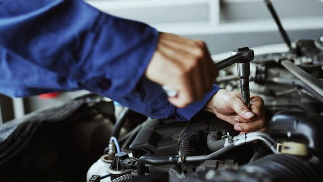 Car mechanic uses wrenches to repair car In the automotive industry. Professional Mechanic with factory work experience. Car maintenance business. Concept key worker
