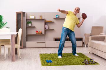 Aged man doing sport exercises at home