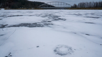 Iron bridge over the ice of the Voronezh reservoir in winter