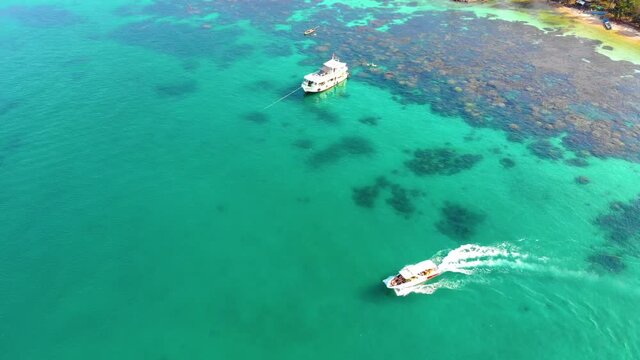 Aerial view of beautiful landscape, tourism boats, and people swimming on the sea and beach on May Rut island (a tranquil island with beautiful beach) in Phu Quoc, Kien Giang, Vietnam.