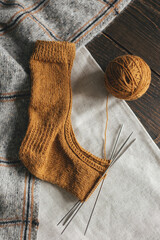 Hand knitted sock with needles and yarn ball.  Concept for handmade and hugge slow life.