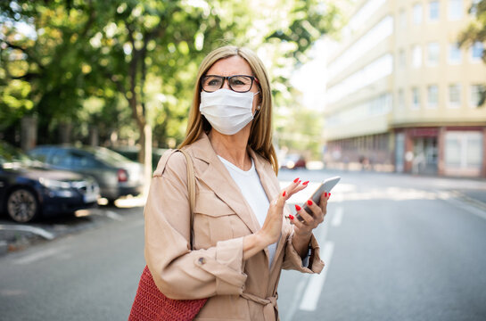 Senior Woman With Smartphone Crossing Street Outdoors In City Or Town, Coronavirus Concept.