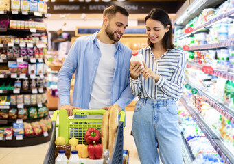 Young happy couple shopping in supermarket together