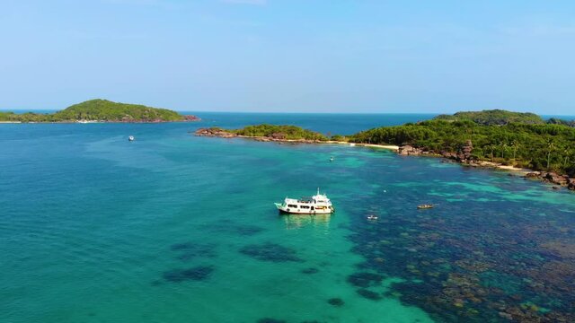 Aerial view of beautiful landscape, tourism boats, and people swimming on the sea and beach on May Rut island (a tranquil island with beautiful beach) in Phu Quoc, Kien Giang, Vietnam.