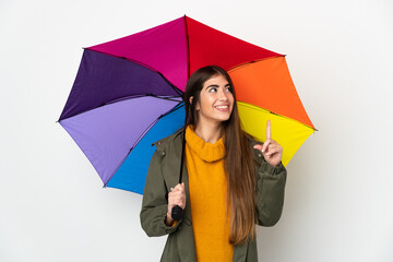 Young woman holding an umbrella isolated on white background pointing up a great idea