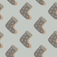 Pale tones seamless pattern with grey winter shoes ornament. Boots with snowflakes on pastel background.