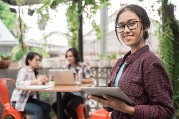 Portrait cheerful of young asian students meeting in a cafe. With friends in the background