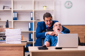 Old male boss and his young male assistant in bullying concept