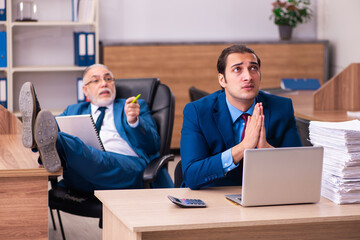 Old male boss and his young male assistant in bullying concept