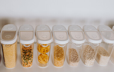 Stocked kitchen pantry with food - pasta, millet, oat flakes, peas, buckwheat, lentils, rice and...