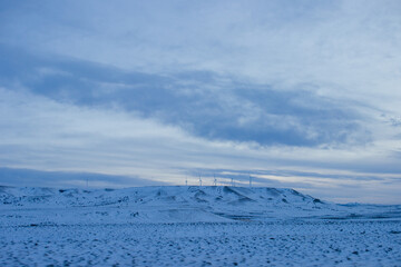 Winter landscape. View of the steppes covered with snow, on which there are wind turbines