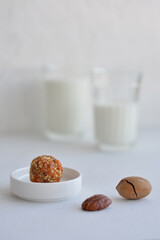 Energy balls. Homemade healthy raw energy balls with carob, figs decorated cocoa with glasses of milk on white background. Sugar free candies and  vegetarian truffles.