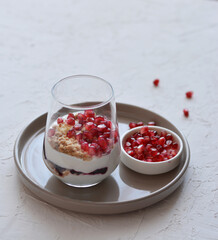Tasty cheesecake with pomegranate in a glass on a white background. Cheesecake without baking. Dessert.