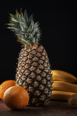 Pineapple with fruit on a dark background