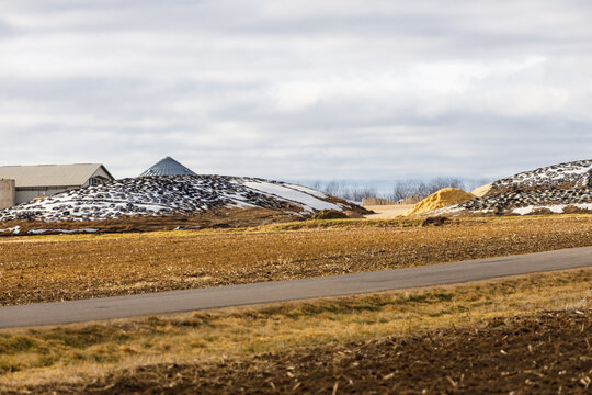 Silage piles on a large dairy farm covered with plastic and cut tires to prevent spoilage. Selective focus, background blur and foreground blur.
