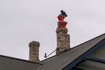 Figur eines Weihnachtsmanns steckt kopfüber in einem Kamin eines Wohnhauses in Reykjavik...