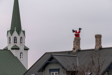 Figur eines Weihnachtsmanns steckt kopfüber in einem Kamin eines Wohnhauses in Reykjavik...