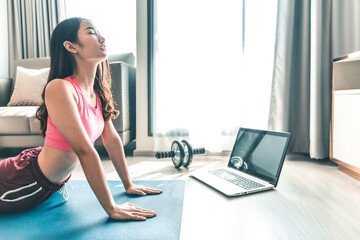 Young asian woman practicing yoga in  gray background.Young people do yoga indoor at home.