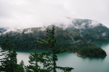 Amazing landscape of lake and forest on foggy hilly terrain