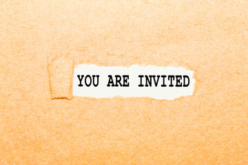 text YOU ARE INVITED on a torn piece of paper, business concept