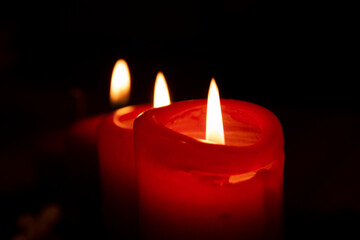 Flame red candles isolated on black background. Close up.