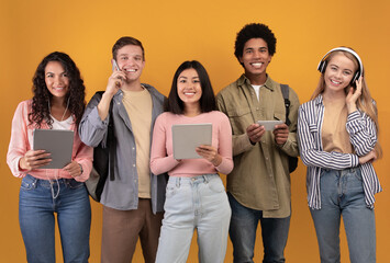 Modern devices, lifestyle and students abroad. Smiling young multiracial people with modern devices