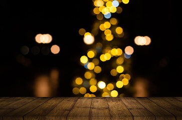 blurred background of xmas tree lights and wall with table of brown color