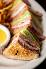 Club sandwich. BLT chicken sandwich. Classic sandwich made with ham, turkey, bacon, cheese, onions, lettuce, tomato, mayo,  salt and pepper. Classic diner or barbecue restaurant favorite.