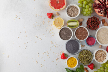 Healthy food: fruit, vegetable, seeds, superfood, cereals, nuts, leaf vegetable on gray concrete background. The concept of a vegetarian diet. Copy space