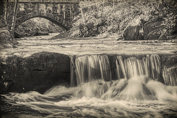 Vintage look at stone bridge and waterfalls of David Fortier River Park, Olmsted Falls, Ohio