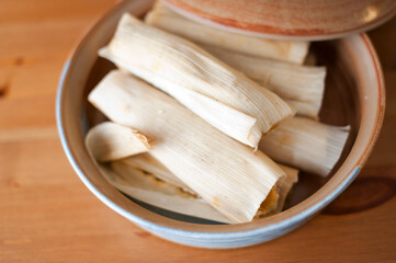 Fototapeta na wymiar Tamales. Classic méso-américain or Mexican cuisine. Seasoned Meats wrapped in masa dough and steamed in corn husks or banana leaves. Traditional regional cuisine.
