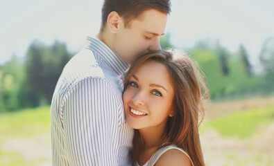 Portrait close up of happy young couple in love hugging outdoors