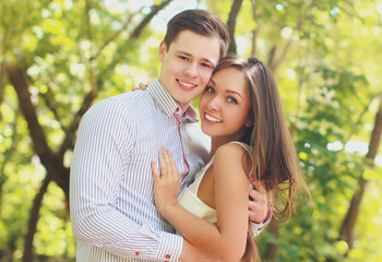 Portrait of happy smiling young couple together outdoors in sunny park
