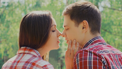 Portrait close up of happy young couple in love kissing outdoors