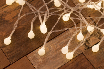Christmas light bulbs on dark wooden background.