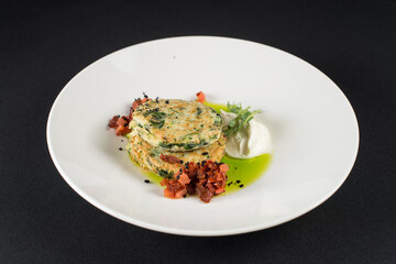 Zucchini pancakes served with sun-dried tomatoes and cream cheese