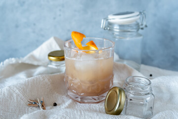 Glass cup with banana and orange cocktail with ice cubes