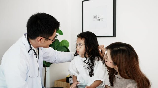The doctor talking to child patient was sitting sad because of sick, uncomfortable with the mother of a child with a fever gradually encouraging her while listening to the doctor's advice.