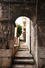 Naklejka premium Old stone staircase. A staircase led through a stone arch.