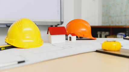 Close up image of a model house with helmet on the desk.