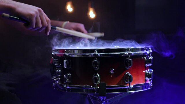 Man playing on snare with drumsticks. Closeup. Slow-motion 